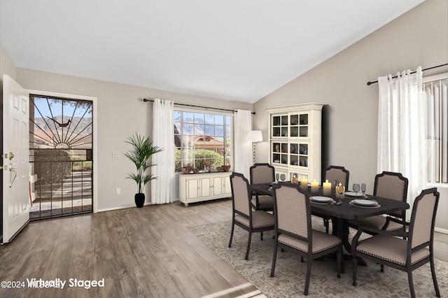 dining area featuring light hardwood / wood-style flooring and vaulted ceiling