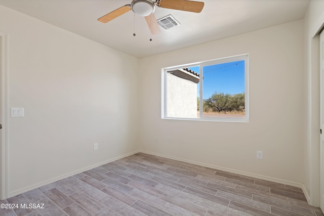 empty room with light hardwood / wood-style flooring and ceiling fan