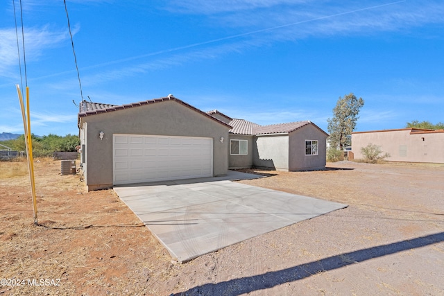 view of front of property with central air condition unit and a garage