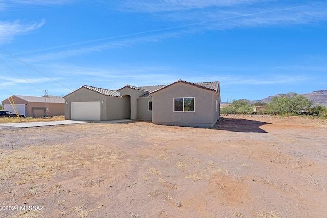 view of front of home with a mountain view and a garage