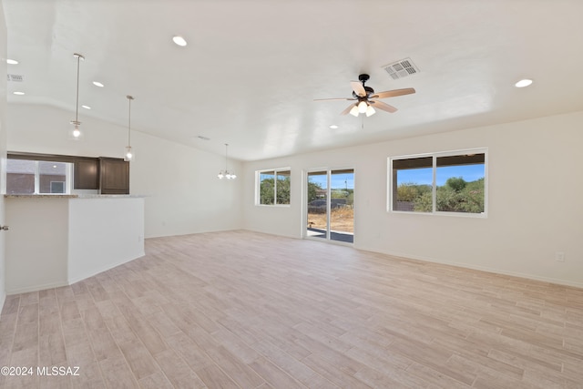 unfurnished living room featuring ceiling fan with notable chandelier, light hardwood / wood-style floors, and lofted ceiling