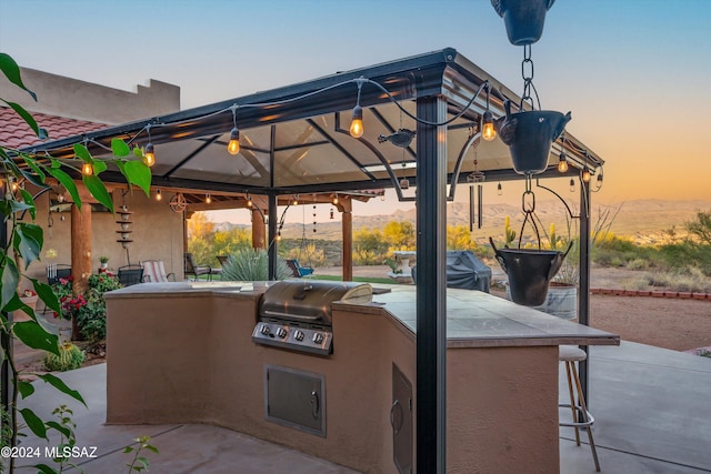 19931 S Sterling Ave, Mammoth, AZ 85618 - patio terrace at dusk with a gazebo, grilling area, exterior bar, and exterior kitchen