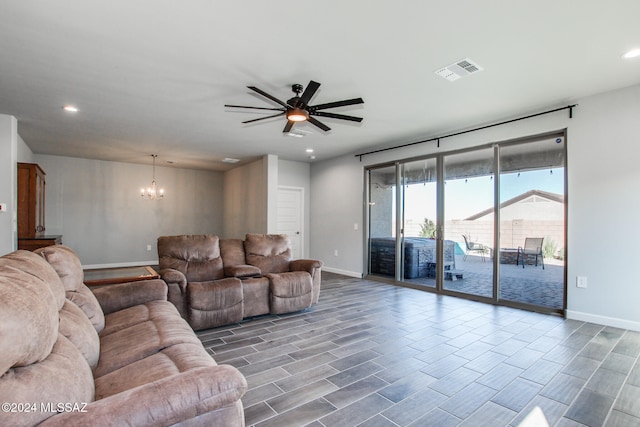 living room with hardwood / wood-style floors and ceiling fan with notable chandelier