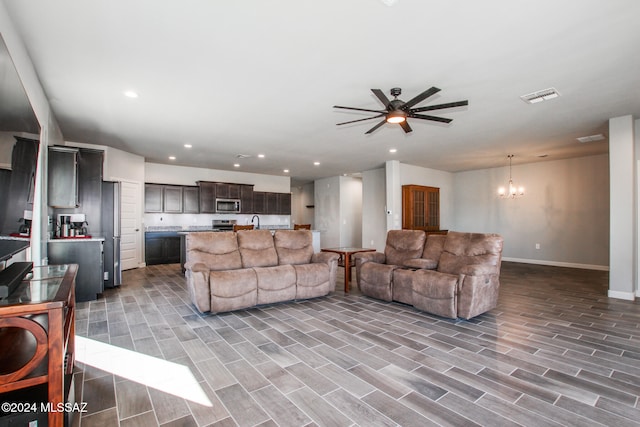 living room featuring light hardwood / wood-style floors, sink, and ceiling fan with notable chandelier