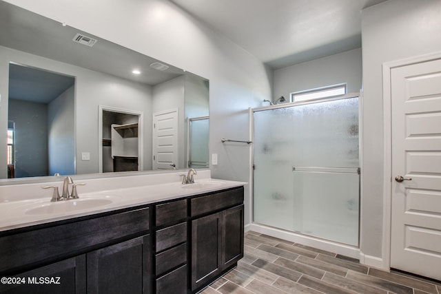 bathroom featuring vanity, hardwood / wood-style floors, and a shower with shower door