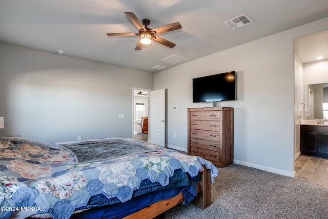 bedroom with ceiling fan, light carpet, and ensuite bath