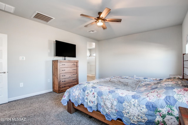 carpeted bedroom with ensuite bath and ceiling fan