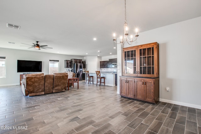 living room featuring hardwood / wood-style floors, ceiling fan with notable chandelier, and plenty of natural light