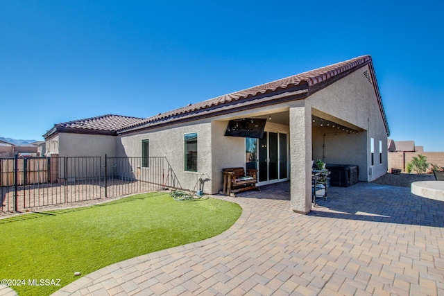 rear view of property featuring a yard and a patio