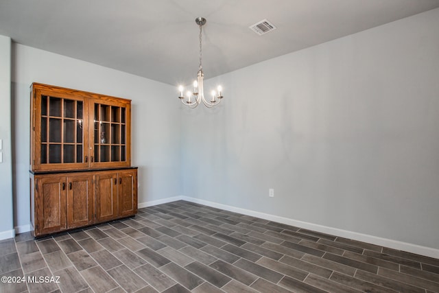 unfurnished dining area with dark wood-type flooring and a notable chandelier