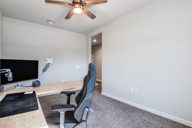 carpeted office space with ceiling fan