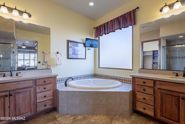 bathroom with plus walk in shower, vanity, and ceiling fan