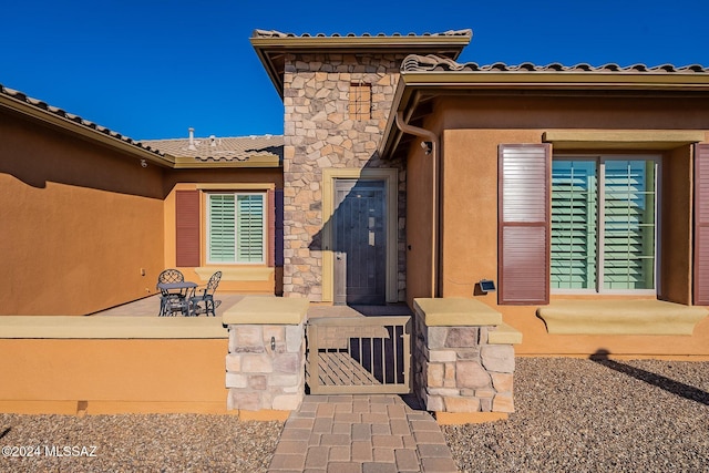 entrance to property featuring a patio area