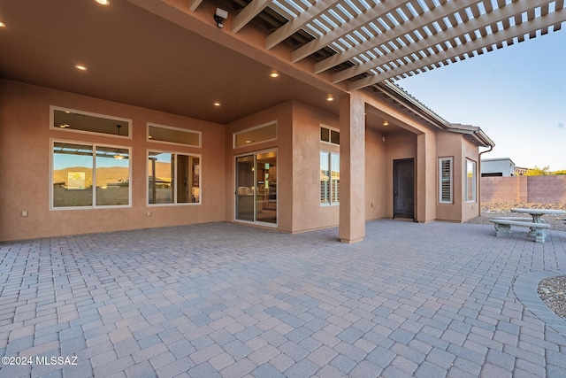 patio terrace at dusk featuring a pergola