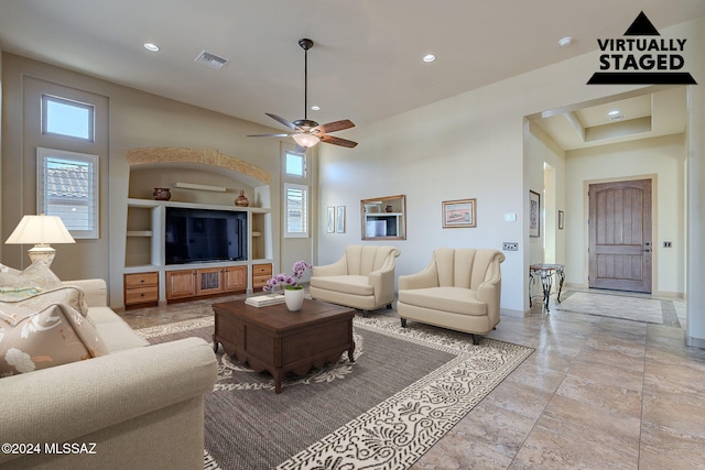 living room with a high ceiling and ceiling fan