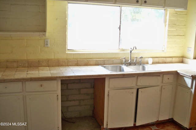 kitchen featuring tile counters, sink, and plenty of natural light