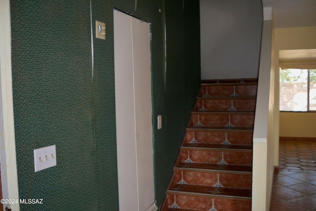 staircase with tile patterned floors