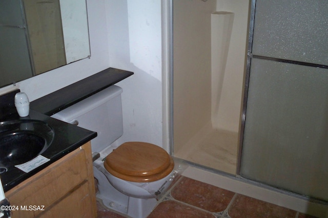 bathroom with toilet, a shower with shower door, and vanity