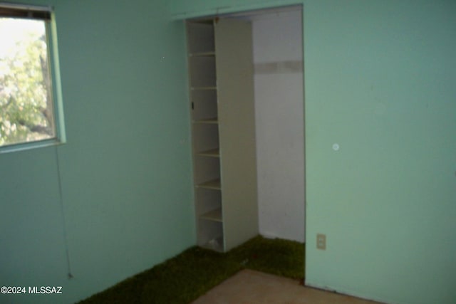 unfurnished bedroom with multiple windows and a closet