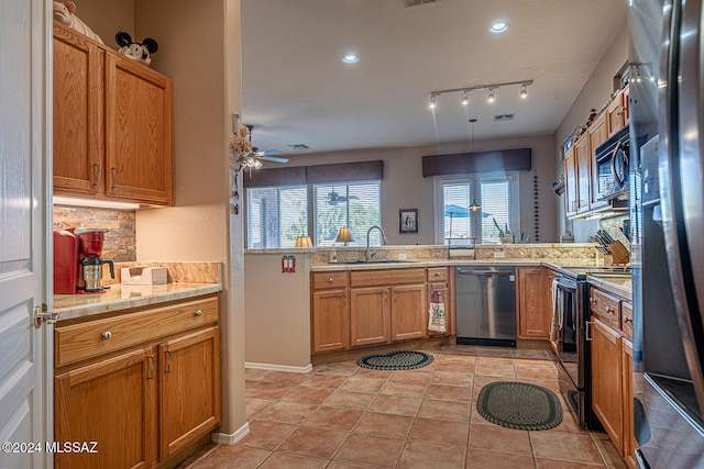 kitchen with black appliances, decorative light fixtures, kitchen peninsula, and sink