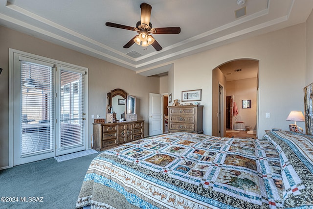 carpeted bedroom with access to outside, ceiling fan, and a raised ceiling