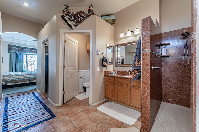 bathroom with toilet, tile patterned flooring, walk in shower, and vanity