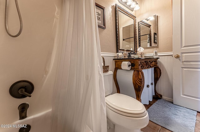 bathroom featuring a shower with curtain, toilet, and tile patterned flooring