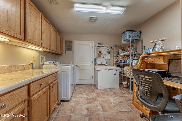 laundry room featuring cabinets, a textured ceiling, and washer and clothes dryer