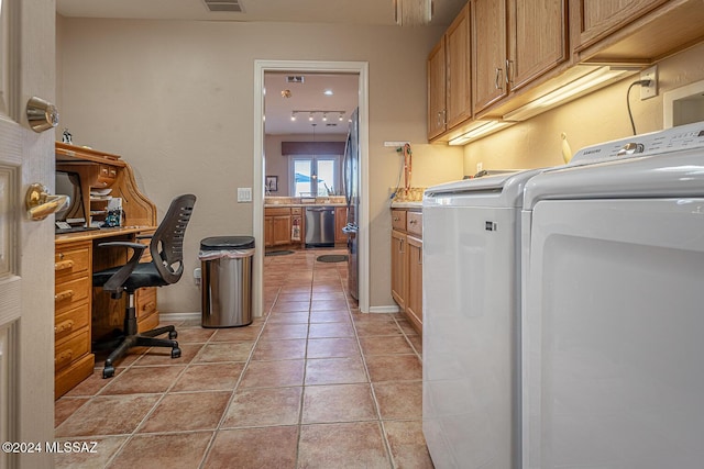 washroom featuring light tile patterned floors, washer / clothes dryer, and cabinets