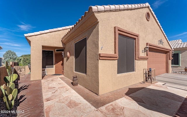 view of property exterior with a patio area and a garage