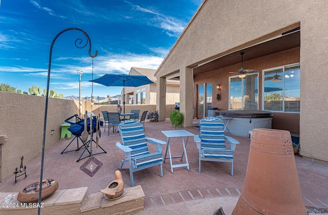 view of patio / terrace with ceiling fan and a hot tub