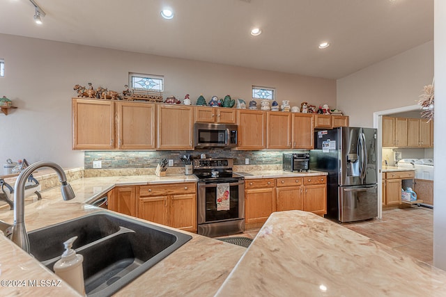 kitchen with tasteful backsplash, light tile patterned floors, sink, kitchen peninsula, and stainless steel appliances