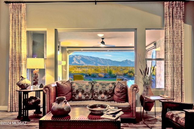 living area featuring a mountain view, ceiling fan, and wood-type flooring