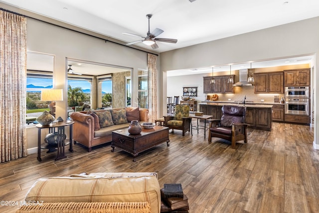 living room featuring hardwood / wood-style flooring, ceiling fan, and sink