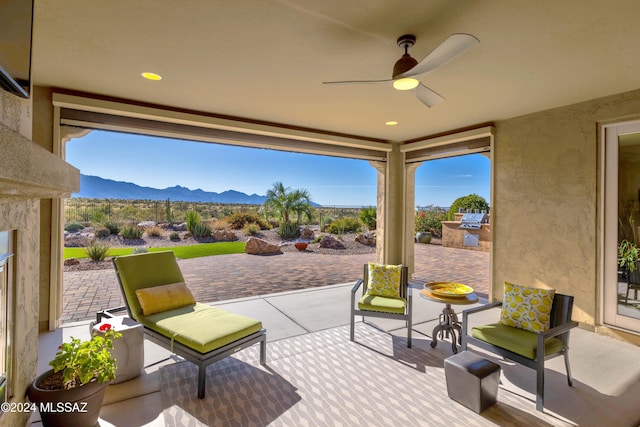 view of patio featuring area for grilling, a mountain view, and ceiling fan