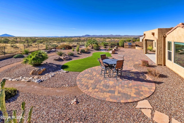 view of yard with a mountain view, an outdoor kitchen, and a patio area