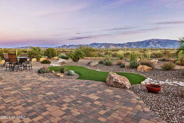 patio terrace at dusk featuring a mountain view