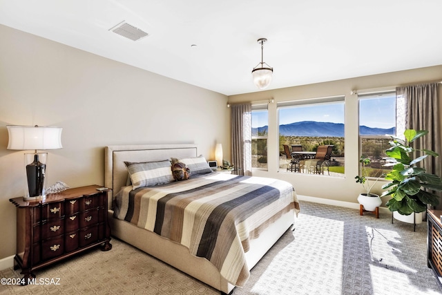 bedroom with a mountain view and light colored carpet