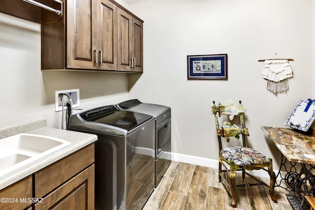 laundry area featuring washer and clothes dryer and cabinets