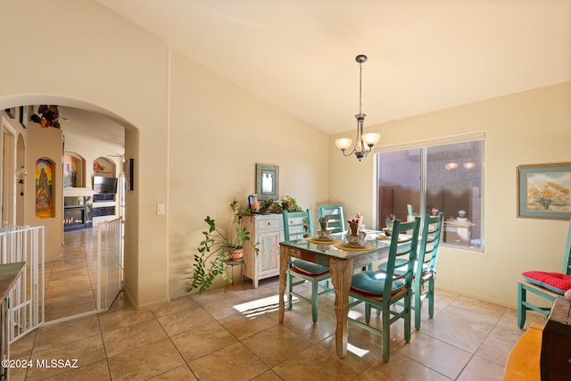 dining space featuring light tile patterned flooring, a notable chandelier, and high vaulted ceiling