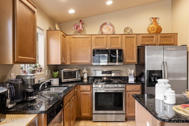 kitchen featuring lofted ceiling, sink, dark stone countertops, light tile patterned floors, and stainless steel appliances