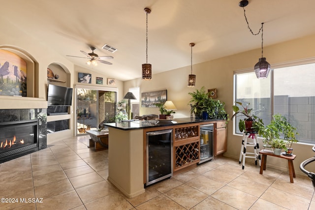 kitchen with wine cooler, hanging light fixtures, built in shelves, and a fireplace