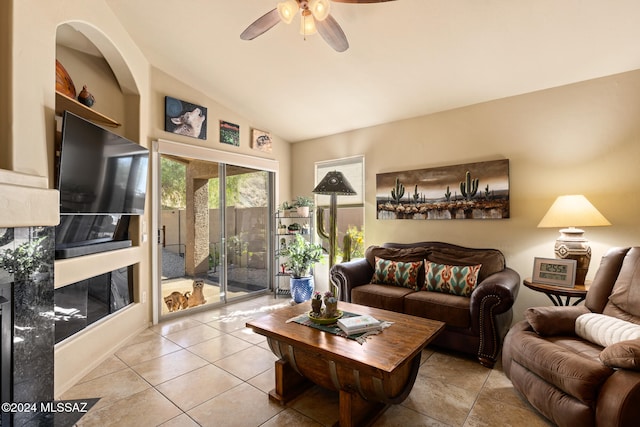 living room featuring lofted ceiling, ceiling fan, and light tile patterned flooring