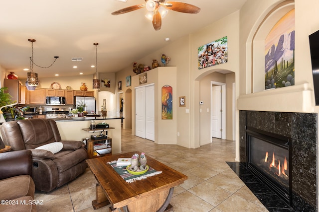 living room featuring ceiling fan, a tile fireplace, and light tile patterned floors