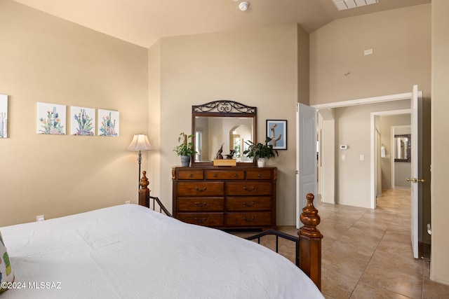 bedroom with high vaulted ceiling and light tile patterned floors