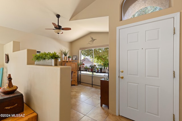 entryway with ceiling fan, lofted ceiling, and light tile patterned floors