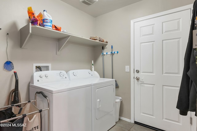 laundry area featuring light tile patterned flooring and washer and clothes dryer