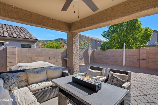 view of patio / terrace with ceiling fan, a mountain view, and an outdoor living space with a fire pit