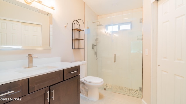 bathroom featuring vanity, toilet, and a shower with door