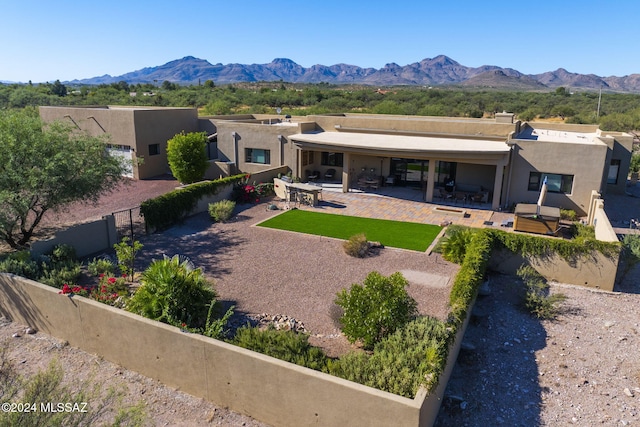 back of property featuring a mountain view and a patio area